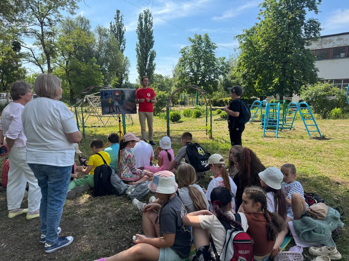 RedCrossUkraine's tweet photo. ☀️ The Ukrainian Red Cross is running mine risk awareness sessions in summer camps and community spaces for children across #Ukraine. Kids learn how to recognise danger and follow key safety rules: Do not approach, do not touch, call 101 or 102. ⚠️ #MineRiskEducation #SafeSummer https://t.co/vfeHlVf4FK