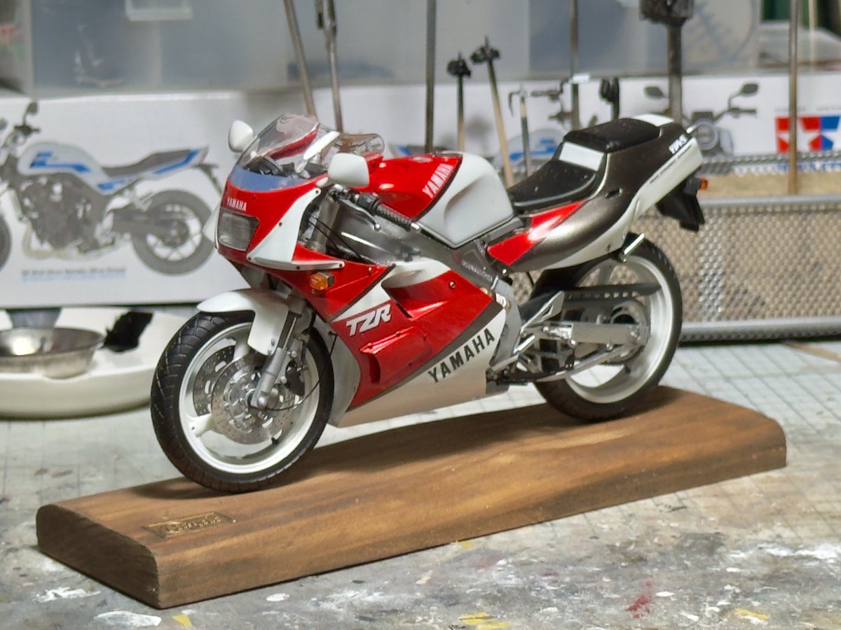 hamachamps's tweet photo. コンデジや一眼カメラを使わず、今あるスマホだけでできる限り高品質なSNS用バイクプラモ写真を撮る方法を考えてみた。

まずサンプルを見てくれ。��方が���リジナルのiPhone写真片方がChatGPT補正後。

バイクプラモ写真は意外と「画質」より「形」が大事。スマホで被写体に近寄って撮ると、広角レンズ特有のパースが強くなり、車体のプロポーションが不自然に見えてしまう。
そこで少し離れて望遠側で撮影する。すると形は自然になるが、多くのスマホではデジタルズーム領域になるため解像感は犠牲になる。そこでChatGPTを使って失われた解像感を補う。

「形は撮影で作る」
「ディテールはAIで復元する」

という考え方。
ChatGPTは無料プランでも生成上限までは利用可能（有料プランは主に利用回数が増えるだけで、写真補正そのものの画質が向上するわけではない）。

「AI補正」と聞くとフェイク画像を連想されがちだが、この方法は存在しないディテールを描き足すのではなく、スマホ撮影で失われた解像感や細部を復元する使い方を目的としている。

下記のプロンプトを添えて補正したいスマホ写真を投げるだけ。なお、プロンプト末尾では「Digital Remaster by ChatGPT. No AI-generated details added.」というキャプションを画像内へ入れるよう指示しているが、文言はお好みで。

——以下をコピペ——

このスマートフォンで撮影したディティールが乏しい写真を高性能な一眼カメラとレンズで撮影したような品質へ修正してください。

元画像に写っている実際の情報のみを使用し、存在しないディテールや物体を創作・追加しないこと。

主な目的は以下です。

・解像感の向上
・微細ディテールの復元
・ノイズ低減
・色収差の補正
・シャドウ部はディティールが残っている場合極力明るく
・可能な限りハイライト部に至るまでの階���を作る
・レンズ性能不足による甘さの改善
・テクスチャの自然な明瞭化

被写体は精密スケールモデルである。
塗装面の質感、デカールのエッジ、タイヤのモールド、金属パーツの表面状態を忠実に保持すること。
過度なHDR処理、過剰シャープネス、過度なコントラスト強調は避けること。

以下は禁止。

・パーツ形状の変更
・模様や文字の描き足し
・実在しない傷や汚れの追加
・ディテールの推測生成
・被写体の改変
・背景要素の追加や削除
・被写界深度の不自然な変更

写真修復・超解像処理として扱い、生成AI的な創作は行わないこと。
「高画質化」ではなく「忠実な情報復元」を最優先とする。
新規ディテール生成禁止。存在する情報の復元のみ許可。
 
 生成画像の四隅のうち被写体を損なわない1つの隅に
 「Digital Remaster by ChatGPT. No AI-generated details added.」
 とキャプション��入れてください。

——以上——

これはGeminiでも使えるが、どうもこのような処理は苦手みたい。明らかにChatGPTより下手だ。