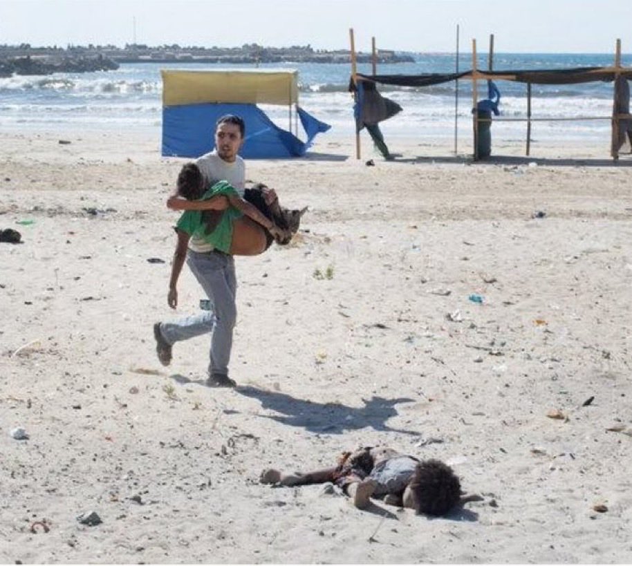 xIsraelExposedx's tweet photo. July 16, 2014, a man carrying an injured child and another lying dead on Gaza City's beach after an Israeli naval strike killed four Palestinian boys aged 9-11. https://t.co/DNC2HGh1Ph