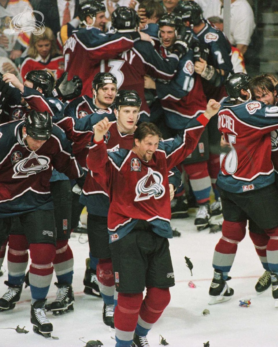 A group of Avalanche players celebrating with rats at their feet after winning the cup