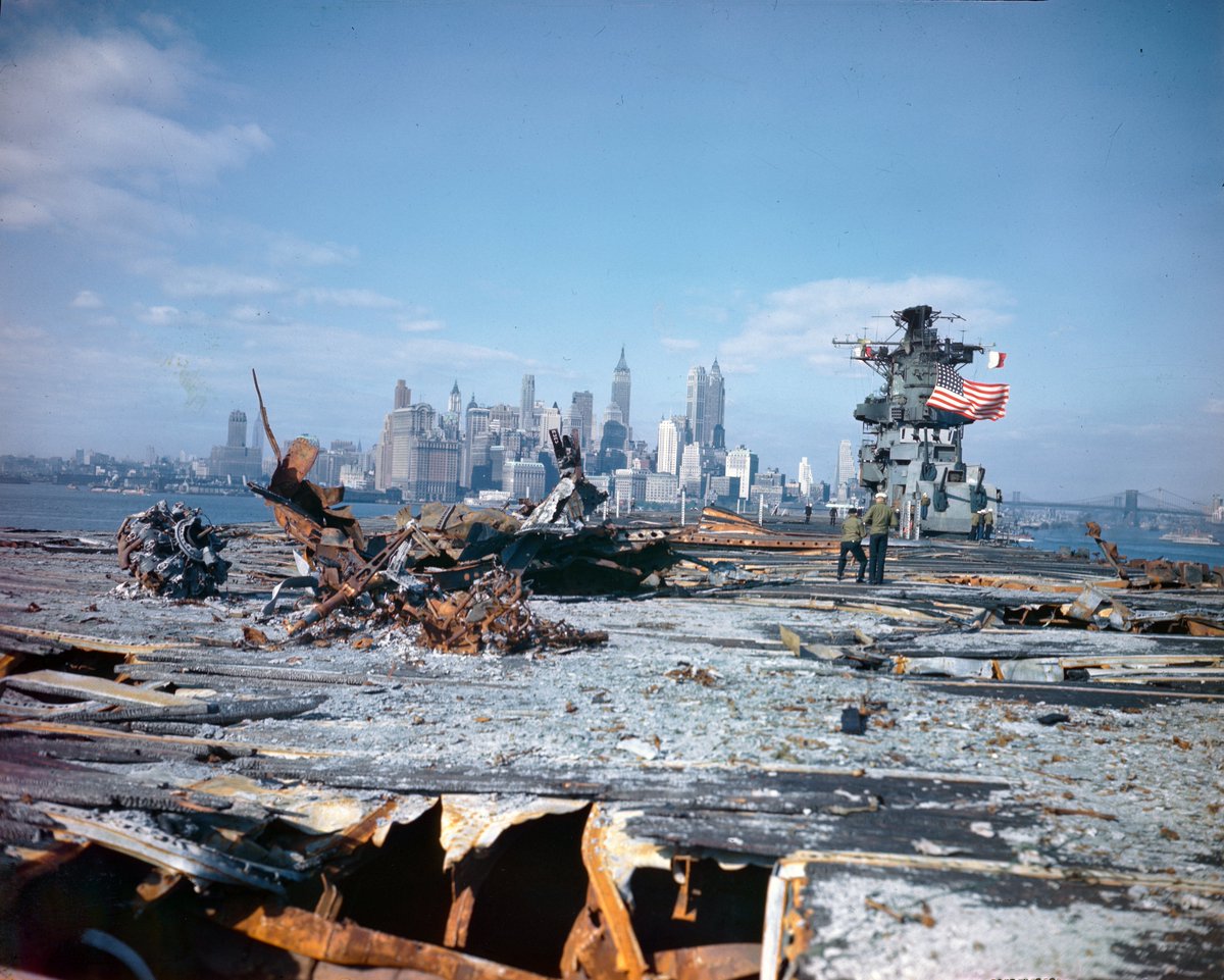 HiddenHistoryYT's tweet photo. The carrier USS Franklin (CV 13) approaches Manhattan as it prepares to dock at the Brooklyn Navy Yard on April 28, 1945. The Franklin’s deck shows the melted and burned decking and aircraft parts resulting from a March 19, 1945, dive bomber attack. https://t.co/Dd3dSIu1lW