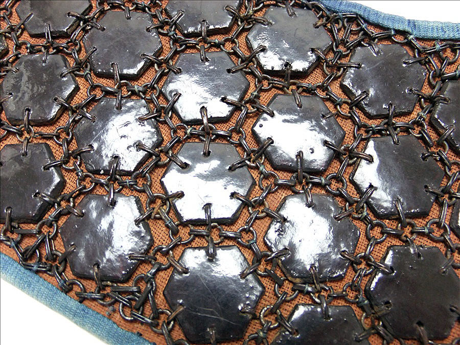 msfugier's tweet photo. I have never seen it this way, but you are right, they kind of look like cucumber slices. 😀

In reality these are tiny hexagonal plates of metal called kikkō-gane). They are sawn into fabric to create an oval protection around the knees (tateage) and are a part of the suneate (shin guard). Below are some pictures to illustrate.