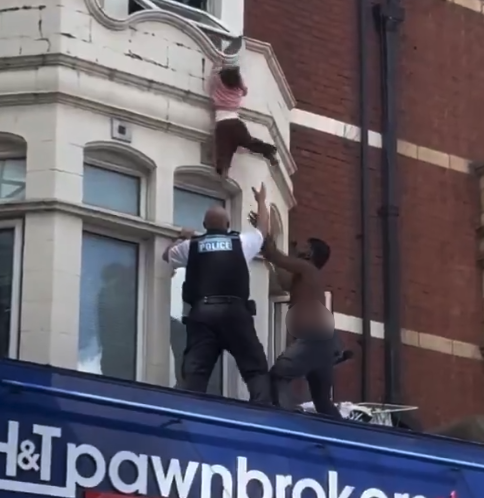 IlmFeed's tweet photo. A hero who saved a girl after she fell from a window ledge in East London has been identified as Mohamed Jesil.

In a video shared on social media, the girl can be seen hanging from a window ledge while members of the public gather below.

Moments later, a police officer and Mohamed position themselves beneath her in an attempt to help.

Mohamed was getting ready for work when he heard the commotion and rushed outside to help, still shirtless.

What followed were a few tense moments as onlookers watched anxiously. Suddenly, the girl lost her grip and fell, but Mohamed managed to catch her and take her to safety.