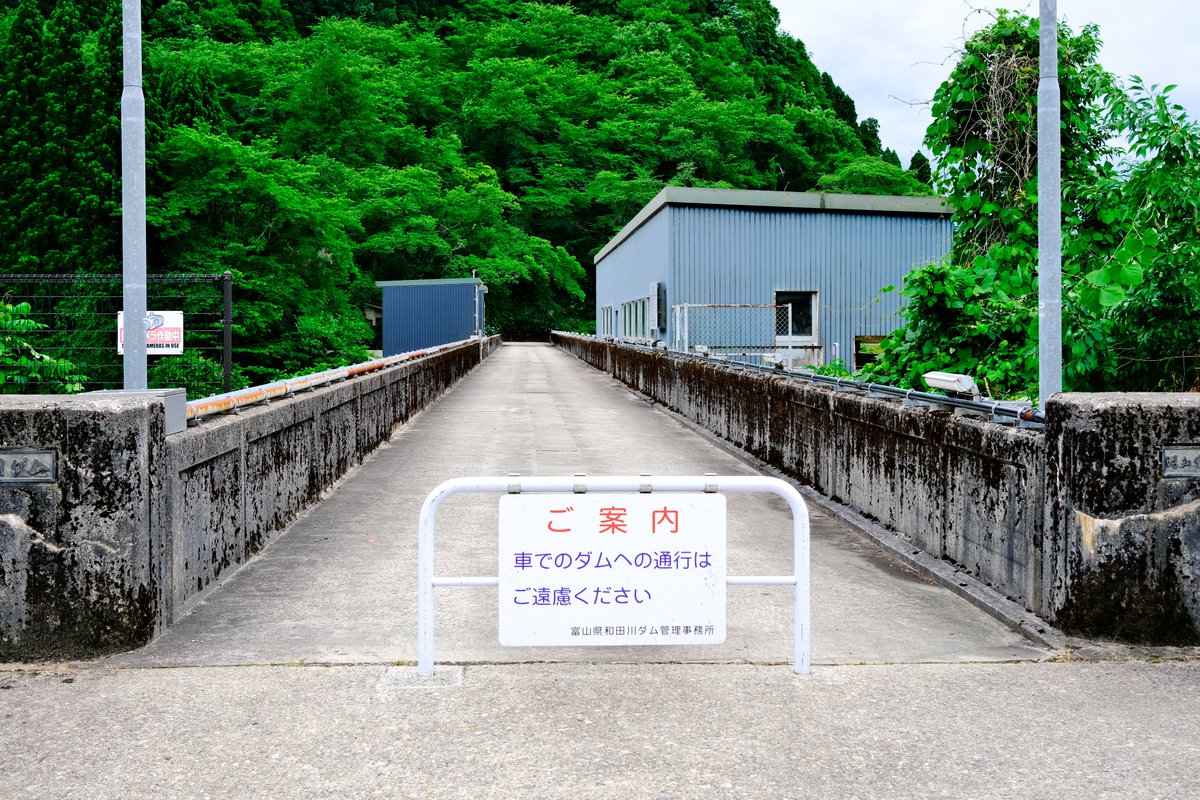 back_backflash's tweet photo. 国道359号線まで戻ってきて、今度は和田川ダムを目指した。この周辺に来るのは多分4‐5年ぶり。堰堤脇にある石碑は竣工当時の表記になっていて、新湊市と小杉町は合併しているがここを訪れる人は限られているので訂正するほどでもないのだろう。何度見ても堰堤下に鎮座している発電所の配置は面白い https://t.co/UkGx3bELSY