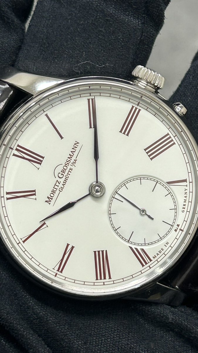 chiitokeyoyogi's tweet photo. 小さな時計屋さんより本日新入荷⑥！！
MORITZ GROSSMANN(モリッツグロスマン) 
【限定7本】 アトゥム エナメル
【2023年7月印】【極美品中古】
型番号：MG-000812

日本限定7本で生産されたアイボリーエナメルダイヤルが特徴的なアトゥムエナメルが入荷致しました。

スイスの名門ドンツェ・カドラン社によるグラン・フーエナメル技法で仕上げられた文字盤は、一般的な塗装やラッカーダイヤルでは決して表現できない奥深い艶と透明感を備えており、柔らかなアイボリーカラーとブルースチール針の組み合わせはクラシカルでありながら気品に満ちた雰囲気となっております。

裏蓋からは自社製手巻きキャリバー100.1を鑑賞する事ができ、ジャーマンシルバー製プレート、手彫りテンプ受け、鏡面仕上げのネジや丁寧に面取りされた各パーツなど、現代では極めて贅沢な手作業による仕上げが随所に施されています。

さらにモリッツ・グロスマン独自のプッシャー機構を採用。リューズで時刻を合わせた後、ケースサイドのプッシュボタンによってムーブメントを再始動させる独創的なシステムは、高精度な時刻合わせを実現するとともに、針飛びの防止や内部に異物が侵入するのを防ぐ役割を持っています。

通常こちらのモデルの製造は2017年頃で、7本限定でありながら2023年にてメーカーからファーストオーナー様に引き渡しをされたとする奇跡のタイムピースでございます。

使用感の少ない個体になり、特記すべき傷もない為極美品中古での販売です。

アリゲーターストラップも使用感が少なくまだまだご愛用頂けるコンディションとなっております。
※内箱に多少の汚れがあります。

次のスレッドに販売価格、商品HPを記載させて頂きますので是非ご覧くださいませ！！

#腕時計
#モリッツグロスマン
#アトゥムエナメル
#MG000812