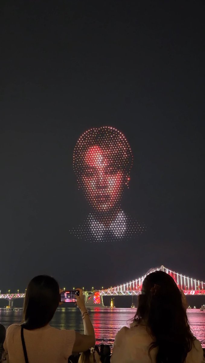 Kpop_Herald's tweet photo. As a warm welcome to fans gathered at Gwangalli Beach, giant drone portraits of @bts_bighit  appear above the shoreline, drawing cheers from the crowd. 💜🎉 (2/2)

#BTS #JIMIN #V #JUNGKOOK #BTS_ARIRANG_BUSAN #BTS_THECITY_ARIRANG_BUSAN https://t.co/WT7WTx4P8i