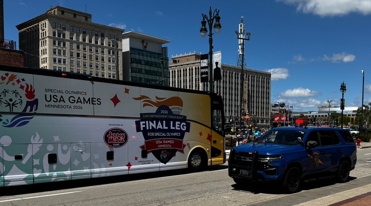 A Michigan State Police cruiser parked next to the Final Leg Special Olympics USA Games bus in downtown Detroit.