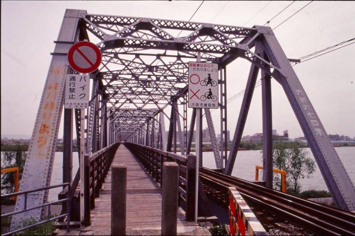 anntomopage's tweet photo. フィルムNo.688のスキャン写真から。
現在は、おおさか東線として旅客営業路線になった、貨物線時代の淀川橋梁。
撮影当時は単線で、複線分の鉄橋の片側に歩道橋として赤川仮橋が設置されていた頃の風景。
撮影当日は今ひとつな天候でしたが、それが逆にレトロでええ感じな写真に。
2002.4.18撮影。 https://t.co/GVNX57jbZk