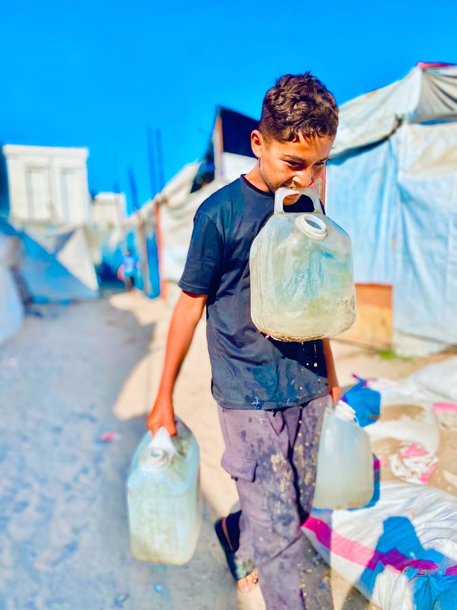 Kahlout9's tweet photo. في هذا الحر الشديد، لا يحمل أطفال غزة ألعابهم ولا
حقائبهم، بل يحملون عبء الماء على أكتافهم الصغيرة. يمشون تحت الشمس الحارقة لمسافات طويلة بحثا عن قطرة ماء تروي عطشهم وعطش أسرهم.
وجوههم المتعبة تحكي قصة معاناة أكبر من أعمارهم، هؤلاء الأطفال لا يطلبون الكثير، فقط حياة كريمة https://t.co/IwyyQuIZUW