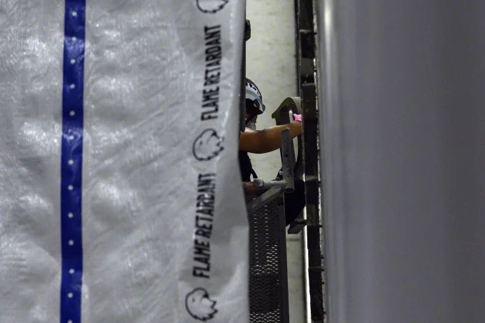 Mollyploofkins's tweet photo. Behind a tarp shielding the work from public view, a worker removes a letter from Trump's name on the Kennedy Center wall. (📷: Cliff Owen/AP) https://t.co/2GQKIV5eZ9