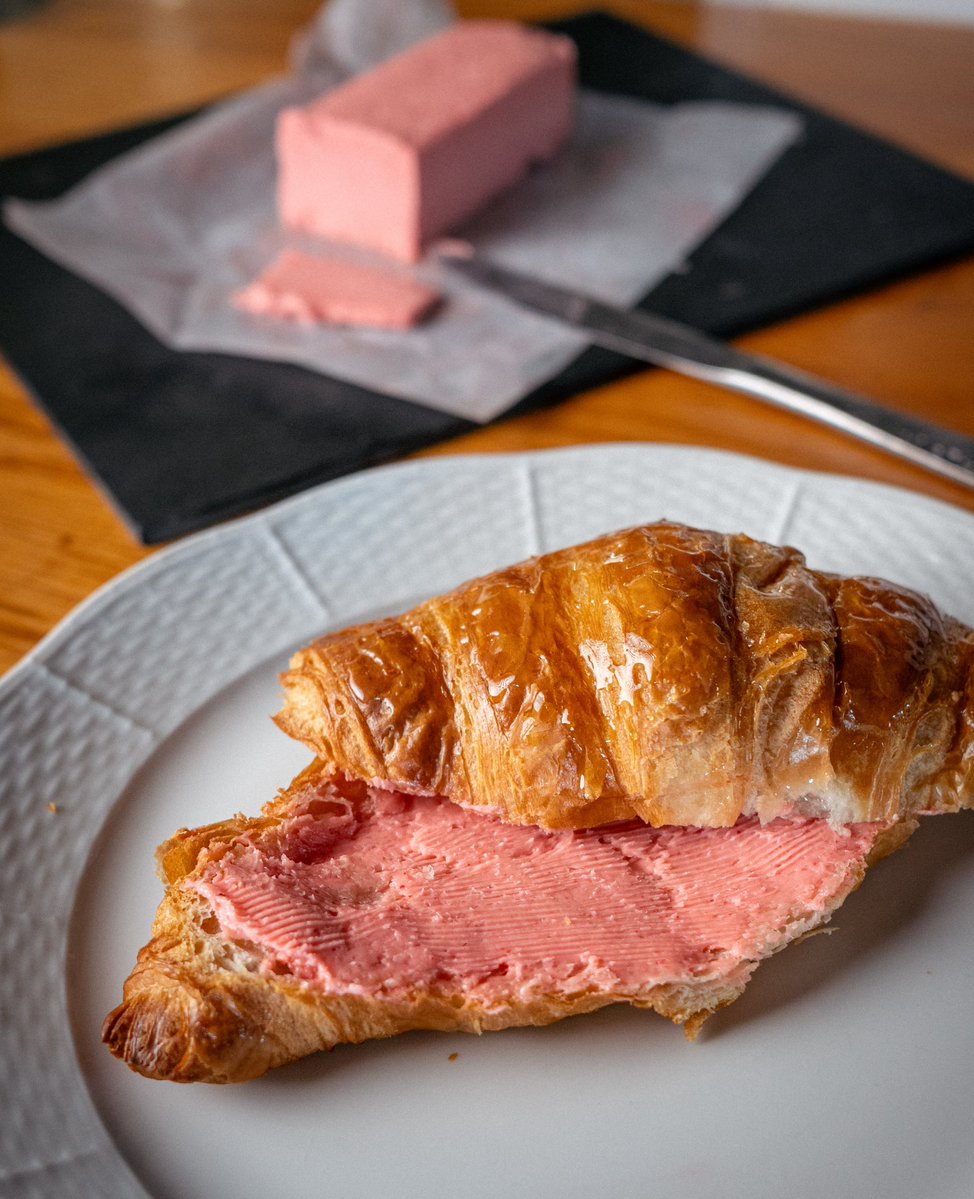 Leon_F_T's tweet photo. It's quite hard to find Raspberry Butter in the grocery store, instead you can easily make your own!

Raspberry Butter Recipe

Ingredients
225 g (1 cup / 2 sticks) unsalted butter, room temperature
100 g frozen or fresh raspberries
2-3 tbsp honey
1-2 tsp lemon juice
1/2 tsp vanilla extract (optional)
Pinch of sea salt (optional)

Directions

Prepare the raspberry compote
Place honey, raspberries and lemon juice in a small pan over medium heat. Bring to a simmer, let raspberries release their juices and collapse. Blend with a hand blender or mash with a fork until smooth. Allow the mixture to thicken, then strain with a sieve to remove seeds. Let it cool to room temperature.

Whip the butter 
Place softened butter in a mixing bowl or a blender. Beat on medium speed for 2-3 minutes until light and fluffy, scraping the sides with a spatula.

Combine
Add the cooled raspberry compote to the whipped butter, with a pinch of sea salt and vanilla if using. Mix on medium speed for 1-2 minutes until fluffy and uniformly pink, scraping the sides with a spatula.

Shape and chill
Spoon the mixture onto a sheet of parchment paper or plastic wrap. Form into a log, roll tightly and refrigerate for 1-2 hours until firm.

Storage 
Keep the log of butter in the fridge for 2-3 weeks, or until original butter's expiry date, and in the freezer for up to 3 months.
