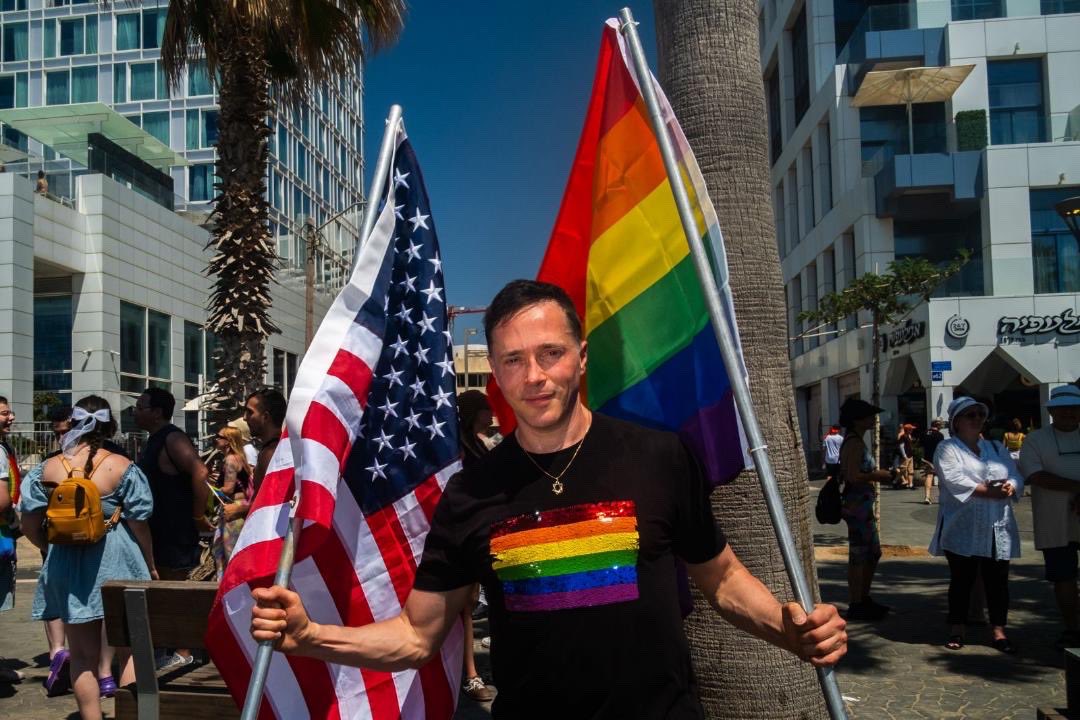 YuvalDavid's tweet photo. Two flags. Three identities. One unapologetic truth.

As a proud Jewish, gay, American-Israeli, I marched through Tel Aviv Pride carrying the Jewish Pride flag and the American flag.

What moved me most wasn’t just the celebration—it was the people. Every few steps, someone stopped me. Some to express their support for what the flags represent. Others because they recognized me from my journalism, advocacy, and activism, and wanted to thank me for the work.

In too many LGBT spaces around the world today, Jews, Zionists, and Israelis are treated as outsiders. Here, I was embraced.

And what I saw was extraordinary: Jews, Muslims, Christians, Druze, religious and secular, left and right, Israeli-born and immigrant, LGBT and allies—people with real differences, standing together in mutual respect, appreciation, and shared humanity.

That’s what makes Israeli Pride different.

It’s not built primarily around protest. It’s built around participation.

Participation in democracy.
Participation in society.
Participation in community.
Participation in life.

Diversity is not a slogan here. It is reality.

I don’t fight back. I fight forward.

And in Tel Aviv, I marched forward with pride, purpose, gratitude, and hope.

🏳️‍🌈🇮🇱🇺🇸

Am Israel Chai.

(Photo credit Viktor Gurevich)