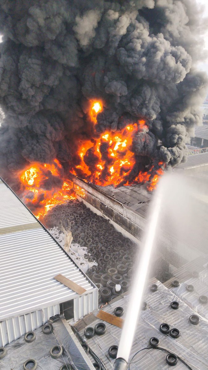 TTISantiago's tweet photo. ALERTA DE TRÁNSITO (10:57). Se mantiene la restricción de tránsito en Piloto Acevedo con Av. Pedro Aguirre Cerda, debido a voraz incendio en fábrica de neumáticos. Equipos de emergencia trabajan en control del siniestro. Humo tóxico en gran parte del sector sur poniente. Evite transitar hacia este perímetro #Cerrillos