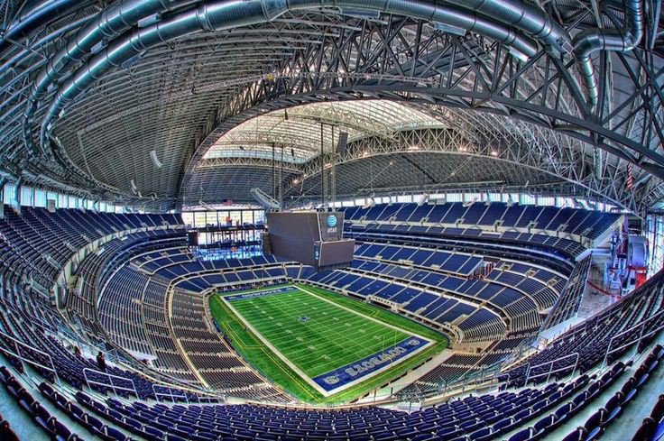 arinzechukwum_'s tweet photo. AT&T Stadium: Another Architectural Engineering Marvel by the Americans

​America keeps proving why they are the absolute best in the world when it comes to sports entertainment. It’s genuinely hilarious how they rebranded and reconstructed a massive American football dome in under six months just to meet strict FIFA standards for the World Cup.

​AT&T Stadium (temporarily renamed "Dallas Stadium" due to FIFA’s strict anti-sponsor rules) is an absolute titan of modern engineering. Built for a staggering $1.3 billion by Dallas Cowboys owner Jerry Jones, this 3-million-square-foot monster in Texas is officially the largest roofed stadium on earth.

​While it comfortably seats 80,000 fans, its flexible design allows it to expand to over 100,000 capacity. The arena is structurally supported by two of the longest single-span steel arches on the planet, features retractable glass walls, and is famous for its legendary, 1.2-million-pound Mitsubishi HD video board hanging directly over the center circle.

​But what makes it truly fascinating right now is how it completely transformed its identity to host elite international football, like the Netherlands vs. Japan match tonight.

​Because the stadium permanently uses artificial turf for the NFL and FIFA strictly demands real grass, engineers spent over 45,000 intense man-hours executing a high-tech pitch overhaul. They hauled in 15,000 tons of material, starting with subsurface ventilation and irrigation networks laid right over the concrete floor, followed by layers of specialized sand.

​They then brought in 24 refrigerated trucks carrying massive rolls of premium hybrid Kentucky bluegrass and ryegrass grown in Colorado. To make the pitch sturdy enough to survive nine grueling World Cup matches, specialized machinery literally stitched millions of synthetic nylon fibers directly into the natural sod.

​The absolute coolest piece of wizardry here is how they keep the grass alive inside a closed dome. Because the roof blocks vital sunlight, they installed a groundbreaking, automated grow-light system suspended directly from the ceiling.

​When turned on, these massive overhead rigs bathe the pitch in a vibrant, glowing pink hue to power photosynthesis. On match days, the entire light system is hoisted 290 feet into the rafters completely out of the fans' sightlines, and once the final whistle blows, they are lowered back down to nurse the grass.

​Just like SoFi, this entire engineering feat is temporary. Once the World Cup wraps up, the hybrid grass will be entirely recycled, and the stadium will shift right back to its standard synthetic turf just in time for the NFL season. The sheer level of flexibility and execution is unreal.