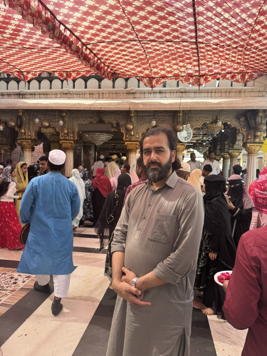 drsameersiddiqi's tweet photo. Today I was blessed to visit the Dargah of Mehboob i Ilahi Hazrat Khwaja Nizam ud din Awliya after a long time. The thin alleys leading to Dargah with rose petals, jaggery and aromas sold on both sides for the visitors makes alleys vibrant and some what fragrant with the occasional burning of incense and the smell of Mughlai dishes being prepared in the eateries, where visitors eat and beggars wait endlessly in queues so that any philanthrope may arrange a feast for them. 
While entering into the Dargah complex, we first entered into the red stone mosque which is also known as the Jamat Khana Masjid and was built by Khizr Khan, the son of Sultan Ala ud din Khilji as a token of respect for Hazrat Nizam ud din. Even Hazrat Nizam ud din used to pray in this mosque and the grandiose of its architecture is really a treat for eyes to behold. 
After Zuhr prayers, we sat alongside the Qawwals who were per chance singing a manqabat of Hazrat Ali and the Qawwals  were singing it in between the mausoleums of Hazrat Nizam ud din and Ameer Khusrau. I could feel with my heart, how Khusrau as a master musician would have made a value addition to the Indian classical Sufi Sema by inventing ragas like Hussaini and by improving upon the instruments like Veena and Sitaar. And it is recorded in the historical sources that it was Ameer Khusrau himself who melodised the words of Hadith “ MAN KUNTO MAULA” into a rhythmic metre and which eventually the aforementioned Qawaals were singing in a high pitch. Further, my imagination reeled back to the saga of love and devotion which Tooti e Hindustan Hazrat Ameer Khusrau manifested for his spiritual beloved…. his beloved Nijaam, in a Brij Bhasha accent. 
Khusrau Nijaam Kay Bal Bal Jayiyay 
Mohey Suhaagan ki ni re mo se  Naina Milai key
It reminded me of many spiritually evolved duos like Shamas and Rumi, Sudhama and Krishna, Nanak and Mardana, and many others who were meant for each other as soul mates winding their ways to the realm of the Eternal together. Using the symbolisms of the worldly love, Khusrau was pointing towards something deeper when he was beholding his Nijaam and was saying: 
Khusrau Ren Sugaag ki Jaagi Piya kay sangh 
Tan Mero Man Piyo ko, Dueoo Bhayay ek Rang
And I was imagining what would have been the state of Khusrau’s mind when the thunder bolt of his beloved Nijaam’s demise would have struck him and when he would have said: 
Gori soyay Sejh par aur Mukh par daaray Kaes 
Chal Khusrau Ghar aapnay, Raen bhayee chuho Daes
“My beloved is resting on a flower bed with tresses of hair on the face
Come back home Khusrau, time has come to return. 
I could feel Ameer Khusrau compiling his Persian Mathnawis and Panegyrics to the beloved Prophet Alaih i Salam, wherein he eulogises him like:
Ay Chehrayyay Zebay i Tu Rashkay Butaan e Aazari 
Har Chand wasfat mi Kunam ammaa az aan Baalaa tarie 
O you my beloved, your countenance is an envy for the images carved out by the master sculptor, Aazar 
Every time I praise you, your stature grows out of the bounds of my words. 
Aafaq ha gar deedah am, Mehrey butaan warzidah am
Bisyaar khubaan deedah am, amma tu Cheezay deegarie 
I have traversed the horizons, I have seen many dear darlings 
I have seen limitless beauties, but O my beloved your are “something” different. 
Khusrau ghareeb ast o ghadaa, uftaadah dar Shahr e Shuma
Baayad ki az Behray e Khuda, Suyay Ghareeban bingarie 
Khusrau is a destitute traveller, stranded in your City
It behoves you that for God sake, do have a look or two upon the travellers as a mark of your courtesy. 
While leaving, I bought some books written by Khwaja Hassan Nizami, the late Sajadah Nisheen of the Dargah, who was a great scholar and literary genius in his own right and had famously held written debate with Dr.  Sir Muhammad Iqbal about his ideas regarding Hafiz Shirazi in his books and letters. But the likes of Hassan Nizami are nowhere to be found these days within the circle of Dargah’s keepers unfortunately.