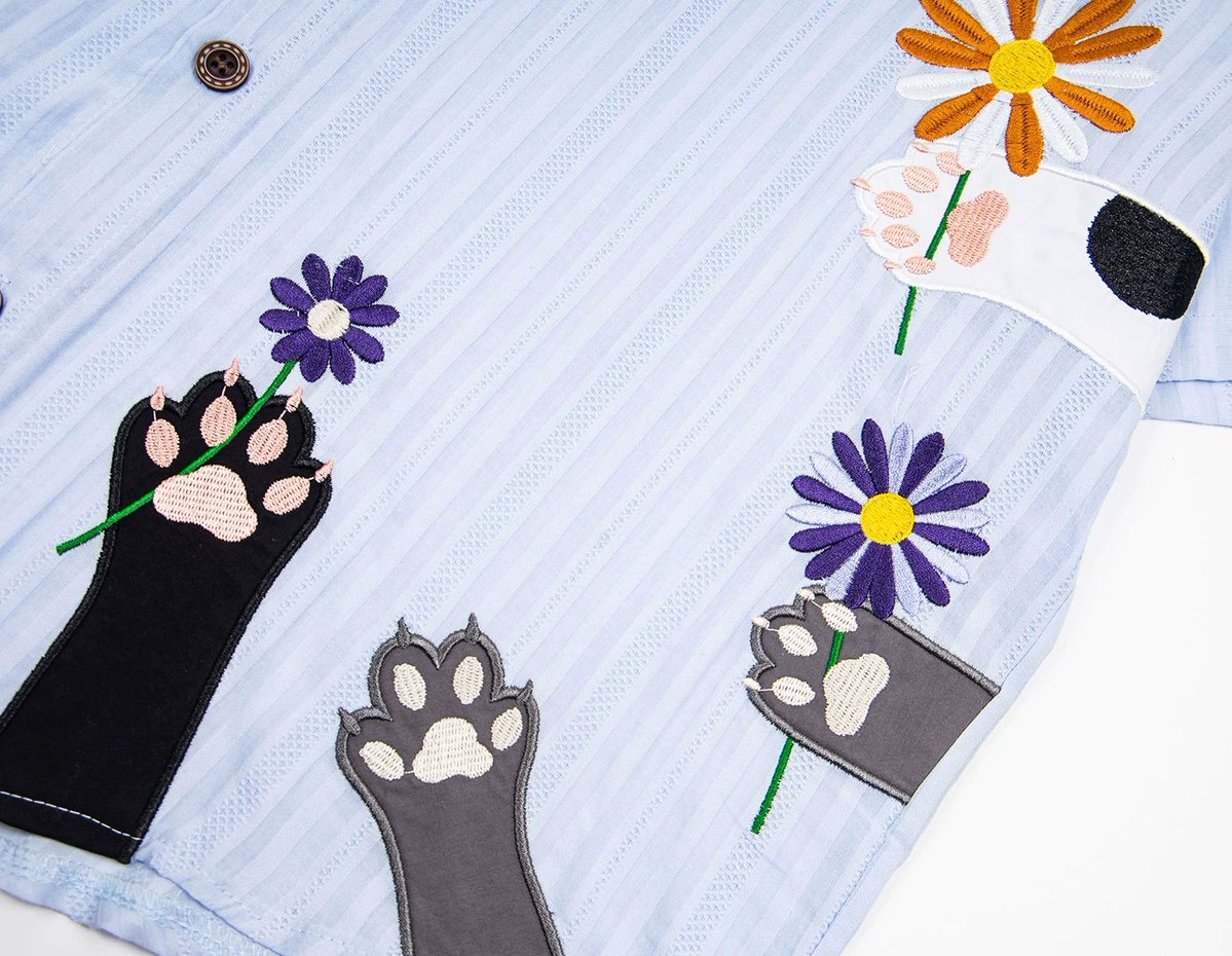 ManusxMachina's tweet photo. 猫と花々の刺繍ネクタイシャツ 
https://t.co/sBdeskJ9cA 
さまざまな毛色の猫の前足が、一輪の花をそっと差し出している様子を刺繍で描いたシャツ。マーガレットやデイジーを思わせる色鮮やかな花々が、爽やかな生地に映え、心温まる雰囲気を演出しています。 https://t.co/ID4MyxM6qV