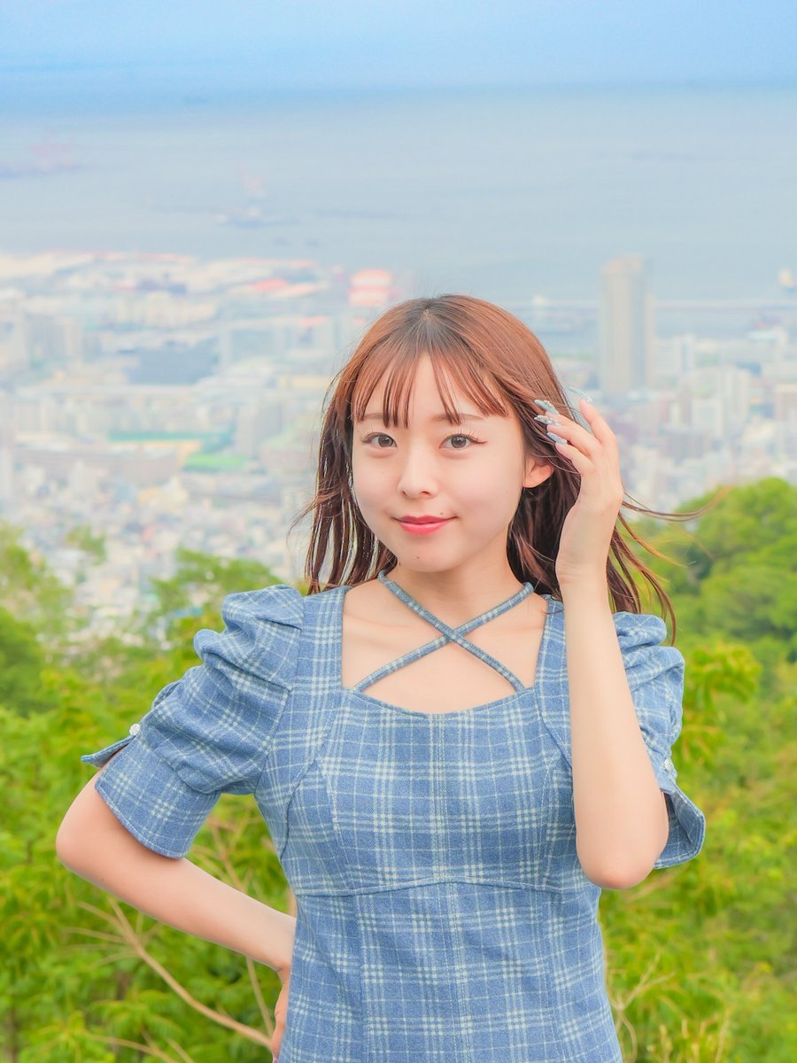 高台を吹き抜ける風に身を 委ねるもっちゃんが海と街 の広がりを感じ
