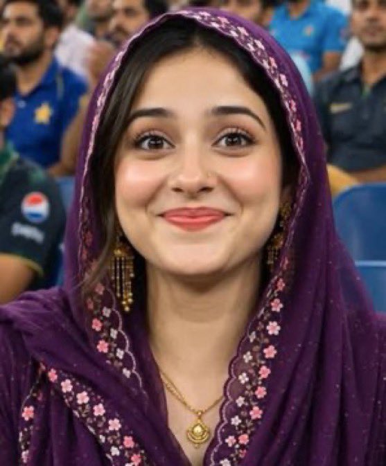 JanParwaaz's tweet photo. आज सोशल मीडिया पर जो स्टेडियम वाली लड़की वायरल हो रही है — गहरे बैंगनी हिजाब में, सोने के झुमके, और वो शर्मीली मुस्कान... कमेंटेटर कह रहा है “That is a very shy natural smile” — सब कुछ इतना रियल लग रहा था कि दिल पिघल गया।   लेकिन सच ये है कि ये पूरी क्लिप AI जनरेटेड है।
 ALFORAT HD LIVE का लोगो, ब्रॉडकास्ट स्टाइल, भीड़, लाइटिंग — सब कुछ आर्टिफिशियल इंटेलिजेंस से बनाया गया।  ये नया स्टेडियम ट्रेंड चल रहा है, जहाँ लोग अपनी फोटो डालकर खुद को मैच में वायरल दिखा रहे हैं। टेक्नोलॉजी सच में कमाल की हो गई है।   रियल है या AI? अब तो पहचानना भी मुश्किल हो गया है ना..?