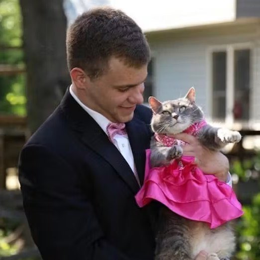 Indie5051's tweet photo. Sin acompañante para el baile de graduación, adolescente lleva a su gata usando un vestido rosa. https://t.co/i6La3ScY5Q