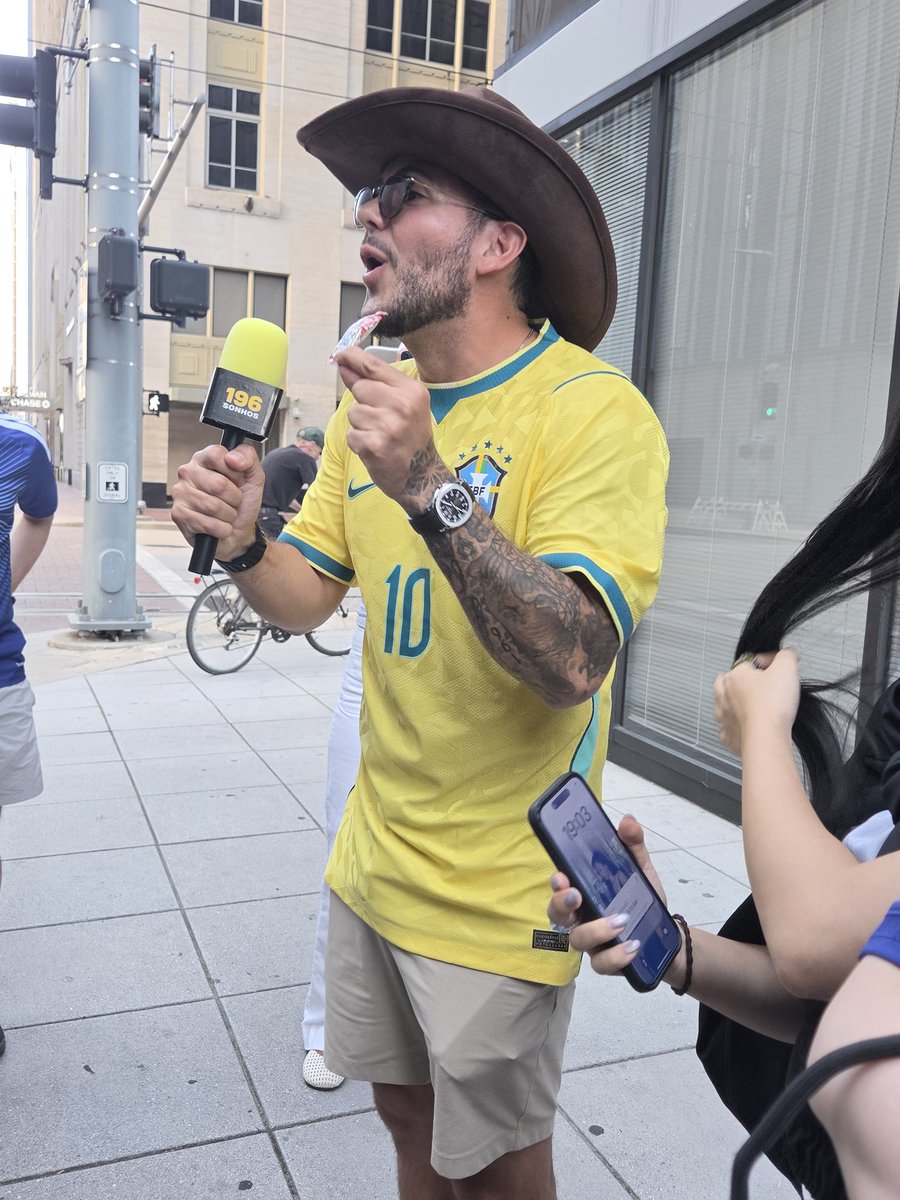 fjmariko's tweet photo. ブラジルのメディア🇧🇷🔍最初｢寿司にケチャップかけるぞー｣というネタでふってきてジェフサポkakeさんの帽子にかぶりつき。｢なんでブラジルカラーなんだ？｣という質問に｢日本で一番有名なクラブのカラーだ｣と小さな嘘を披露！この嘘広まれ🤣 #jefunited #FIFAWorldCup #サッカーＷ杯日本代表 https://t.co/iK58kQfjNB