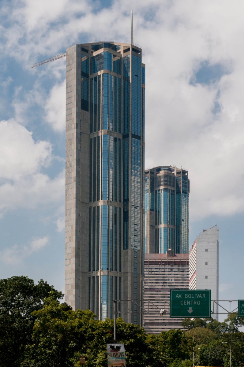 Mibelis's tweet photo. Para ser justos y agradecidos: entre otras importantes obras arquitectónicas, hay que mencionar también a las Torres de Parque Central en Caracas. Construidas en los 70 por el Centro Simón Bolívar, sus estructuras fueron calculadas por ingenieros venezolanos, integrando un sistema de armado flexible y resistente. Son íconos de la ingeniería sismorresistente en América Latina, de hecho. Esas estructuras de concreto armado se concibieron para disipar la energía de los terremotos, adaptándose a la alta actividad sísmica del valle de Caracas.