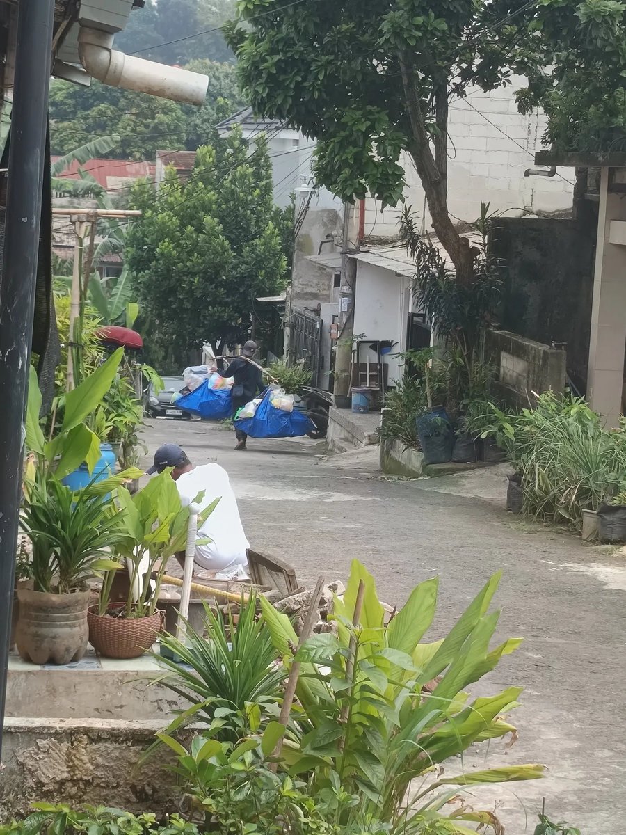 atokdalangs4's tweet photo. Belakangan ini rasanya makin sering lihat orang kecil yang harus berjuang lebih keras buat cari nafkah. Tadi ada abang jualan perabot keliling lewat depan rumah, tapi bukan pakai mobil seperti biasanya. Semua dagangannya dipikul pakai bambu.

Awalnya aku sama mamaku memang nggak ada niat beli. Tapi pas lihat cara beliau jualannya, rasanya nggak tega kalau dilewatin begitu aja. Akhirnya kami beli perabot sekitar Rp20 ribu, padahal uang itu sebenarnya mau dipakai buat beli beras.

Mamaku sempat tanya, "Bang, kok sekarang dipikul? Biasanya kan pakai mobil."

Abangnya cuma senyum lalu bilang kalau sekarang sudah nggak sanggup bayar sewa mobil. Katanya sejak harga bahan plastik naik, dagangannya jadi makin sepi.

Mamaku juga tanya rumahnya di mana. Ternyata beliau tinggal di Cibinong, sekitar 5–6 km dari rumah kami. Kebayang dong, jalan sejauh itu sambil memikul dagangan yang berat.

Aku kasih uang lima puluh ribuan. Abangnya sampai bilang, "Maaf ya, Teh, kembaliannya receh. Ini baru penglaris hari ini."

Aku cuma jawab, "Nggak apa-apa, Bang. Semoga hari ini dagangannya laris."

Setelah masuk rumah, aku sempat foto abang itu dari jauh lalu kirim ke kakakku. Begitu lihat fotonya, kakakku langsung bilang mau ikut beli juga. Dia bahkan mau transfer uang Rp100 ribu buat dibelanjain. Sayangnya abang itu nggak punya HP, jadi nggak bisa terima transfer.

Akhirnya aku lari ngejar beliau. Waktu ketemu, ternyata abang itu sudah lewat beberapa gang dan lagi duduk istirahat di pos karena kecapekan. Beliau sampai heran kenapa aku nyusul sejauh itu.

Aku bilang kalau kakakku juga mau beli beberapa barang. Abangnya langsung semangat lagi, ramah banget jelasin harga satu per satu sambil bilang kalau sekarang beberapa barang memang naik harga.

Pas selesai belanja, senyum beliau langsung beda. Wajah yang tadi kelihatan capek dan lesu jadi cerah. Beliau berkali-kali ngucapin terima kasih sambil mendoakan semoga rezekiku selalu lancar.

Jujur, momen itu bikin aku terharu. Kalau suatu hari kalian ketemu pedagang keliling seperti ini dan memang ada rezeki lebih, coba deh beli satu atau dua barang. Mungkin nilainya kecil buat kita, tapi buat mereka, satu pembeli bisa jadi penyemangat untuk terus bertahan mencari nafkah.