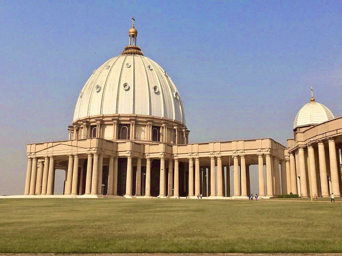 shavnyuy's tweet photo. The same energy we direct into building churches across this continent should be equally directed to schools, hospitals and museums. We build the most important spaces as though they are temporary. We build churches for eternity.

The Basilica of Our Lady of Peace in Yamoussoukro, Côte d’Ivoire, is the largest church in the world by area, deliberately designed to surpass St Peter’s Basilica in Rome. 30,000 square metres. A dome rising 158 metres. 272 Doric columns. 18,000 worshippers inside with space for 300,000 on the esplanade. Built between 1985 and 1989 at an estimated cost of $300 million, which doubled the national debt of a country where most homes in the surrounding city had no running water.

President Félix Houphouët-Boigny built it in his own birthplace, commissioned a stained glass window depicting himself kneeling beside Jesus, and gifted the entire structure to the Catholic Church. Pope John Paul II initially refused to consecrate it and only agreed after the government promised to build a hospital nearby.

The hospital was the condition. The basilica was the priority.

Only 17 percent of Ivorians identify as Catholic. Regular services attract a few hundred people. The only time the building was filled to capacity was for Houphouët-Boigny’s own funeral in 1994.

We know how to build for permanence on this continent. We just keep deciding who deserves it.

Basilica of Our Lady of Peace | Yamoussoukro, Côte d’Ivoire | Architect: Pierre Fakhoury | Completed