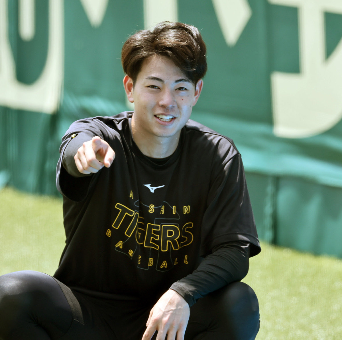 dailytigers2026's tweet photo. デビュー戦を控える下村投手。練習中からいい表情です。後ろに座る今朝丸投手のサングラスがキラッと光っています🤩 https://t.co/vhZwmGGow2
