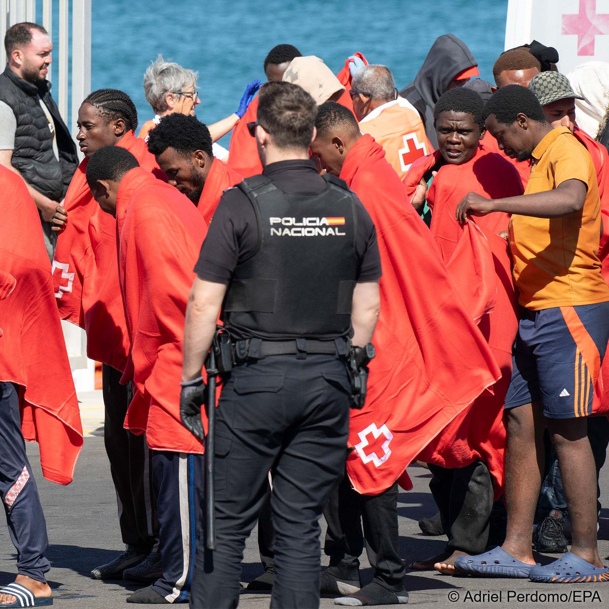 InfoMigrants's tweet photo. A group of migrants arrive at Arrecife port in the Canary Islands, Spain, June 14, 2026, after being rescued by Spain’s Maritime Rescue service @salvamentogob  from an inflatable boat near Lanzarote. At least 77 people were rescued, including 6 women and 3 children. https://t.co/AX6k0coDZH