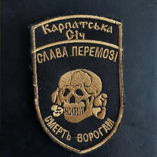 HavryshkoMarta's tweet photo. Ihor Kostiuk, an officer of the Karpatska Sich Battalion of AFU, is proudly showing off his brand-new Nazi Totenkopf patch.

Attention: if you happened to notice it, you are officially a Kremlin agent!

Please report yourself immediately to the Security Service of Ukraine, confess your thoughtcrime, and begin the process of repentance. 

Questions are forbidden.
The patch is invisible to patriots and "Slava Ukraini" folks in the West.