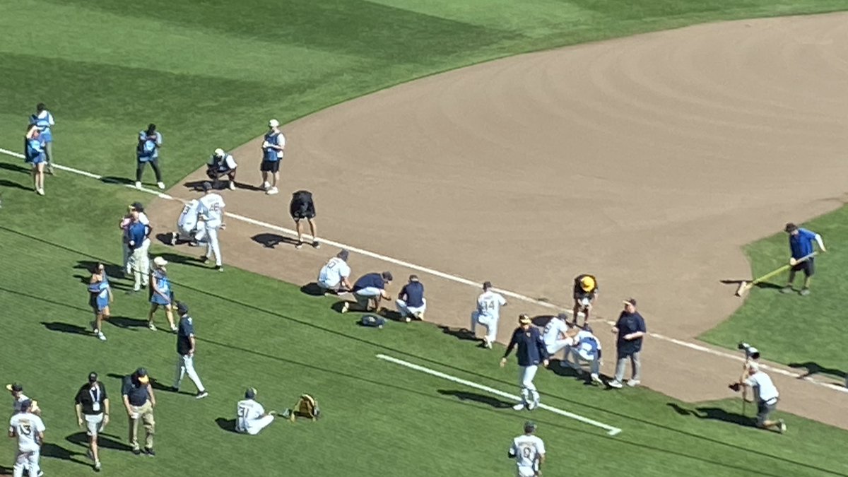 ESPNMcGee's tweet photo. West Virginia players scooping up a little baseline dirt. And they should. The Mountaineers won this city over. #MCWS https://t.co/6jflFhEygY