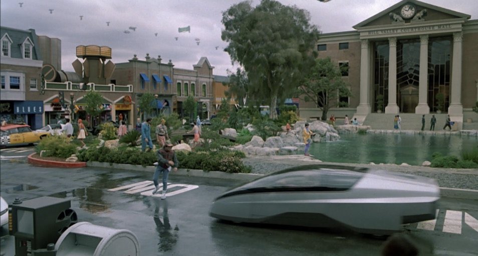 FilmEasterEggs's tweet photo. In the Back to the Future Trilogy (1985-1990), Marty nearly gets run over every time he first explores a new iteration of the Hill Valley Courthouse Square https://t.co/OqMtCM9mHt