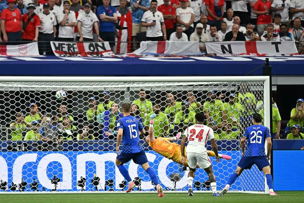 denimenezes14's tweet photo. INGLATERRA, SEGUNDO TÍTULO DEPOIS DE 60 ANOS
Copa do Mundo

COTADA entre as favoritas, a Inglaterra estreou com boa atuação e vitória sobre a Croácia por 4 x 2, diante de 70.389 torcedores, nesta 4ª feira (17), no AT&T Stadium, em Arlington, no estado do Texas, focada no segundo título, 60 anos após ser a terceira das seis seleções a ganhar em casa a Copa do Mundo, com 4 x 2 na Alemanha, na decisão de 1966, em Londres.

COM DOIS GOLS, Harry Kane igualou-se a Gary Lineker, até então único com 10 gols pela seleção inglesa, artilheiro da Copa de 1986, com 6, e 4 gols na Copa de 1990. Kane também passou a ser o terceiro com mais jogos (115) pela seleção, igual a David Beckham, depois do goleiro Peter Shilton (125) e do atacante Wayne Rooney (120).

PARA ABRIR o placar, aos 12 minutos, Harry Kane teve que bater o pênalti duas vezes. Na primeira, o goleiro Livakovic defendeu, mas se antecipou à cobrança, e o árbitro francês Clement Turpin mandou repetir. Na segunda, marcou no canto esquerdo e tornou-se o primeiro da história das Copas a converter cinco pênaltis.

ALÉM DISSO, Harry Kane livrou-se do fantasma da Copa de 2022, quando isolou uma cobrança de pênalti, aos 39 do 2º tempo, nas quartas de final, em que a Inglaterra poderia ter ido à prorrogação, mas foi eliminada pela França (2 x 1). Kane havia feito o gol da Inglaterra, aos 9 minutos, deslocando o goleiro Hugo Lloris na cobrança de pênalti.

A CROÁCIA empatou aos 36, com o meia-atacante Martin Baturina, de 23 anos, do italiano Como FC, de fora da área. Kane recolocou a Inglaterra em vantagem, aos 42, e o atacante Petar Musa, de 28 anos, do Dallas FC, da Liga dos Estados Unidos, voltou a empatar.

NA VOLTA DO INTERVALO, logo aos 2 minutos, Jude Bellingham, do Real Madrid, marcou o 3º gol, a Inglaterra manteve o jogo sob controle, e fechou o placar aos 40, com Marcus Rashford, ponta-esquerda de 28 anos, campeão espanhol com o Barcelona, que não exerceu a cláusula de compra, e ele volta ao Manchester United para a temporada 2026-2027.

Fotos: PAUL ELLIS / AFP