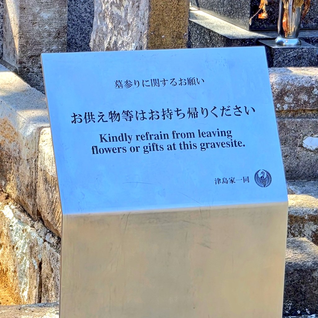 sbr_QQQ's tweet photo. 太宰治のお墓。ご親族がわざわざ｢お供え物等はお持ち帰りください｣と、わかりやすい看板を設置されたにも関わらず、供え物があるとのこと。

文章を読めない方々は、本当に文豪のファンなのか………？？？
(※画像は今年の5月。三鷹市からアナウンスがあった後) https://t.co/sNjSn0d47A