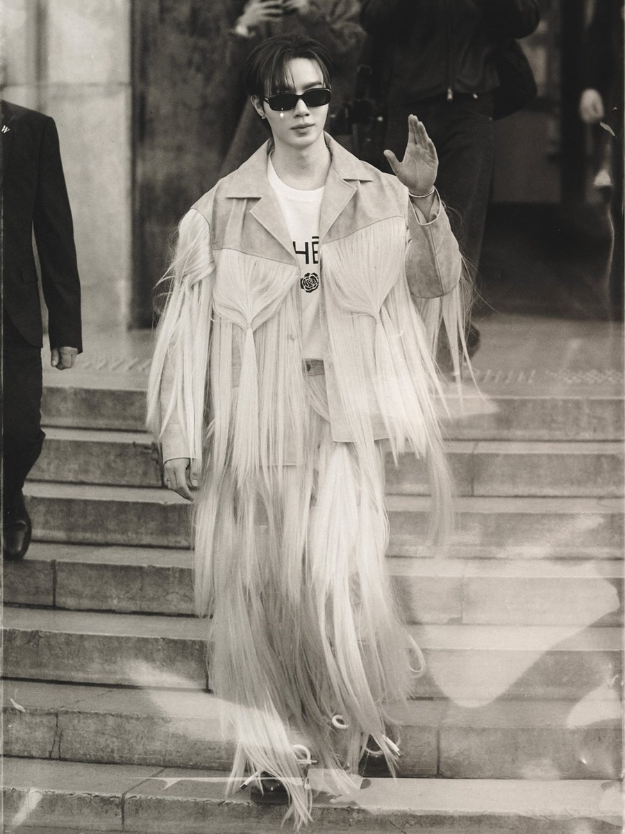 ZeePruk_Spain's tweet photo. 📸 ©IG: letizia.campanella 
https://t.co/1ABk9AOeZh

Thanks to letizia.campanella for these exclusive images captured during the event, evoking a nostalgic and cinematic aesthetic in black and white and desaturated tones, showing a Zee Pruk completely intertwined with the experimental DNA of the brand founded by Kiminte Kimhekim. 🖤✨

The KIMHĒKIM design worn by Zee Pruk belongs to one of the brand's most disruptive collections, famous for its volumes and the use of hair textures.
It consists of:

A spectacular two-tone structured jacket.
Cascading fluid fringes of platinum blonde hair falling from the chest, back, and sleeves.
Matching trousers that blend with the design, creating an ethereal movement with every step.

No top-tier styling is complete without its accessories and jewelry, and on this occasion, the details were responsible for crowning a perfect look.

Upon leaving the venue, surrounded by strict security measures and a wave of fans chanting his name, Zee took a moment to sign autographs and greet everyone with his characteristic elegance and warmth.

@zee_pruk @maisonkimhekim

ZEEPRUK LOGIN TO PFW 
#KIMHĒKIMxZeePruk 
#KIMHĒKIM 
#PFW2026 
#ZeePruk #지프룩