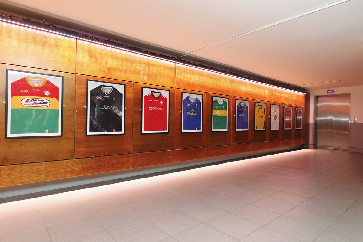 A section of Dublin Airport’s new GAA exhibition featuring framed county jerseys displayed along a brightly lit arrivals corridor in Terminal 1.