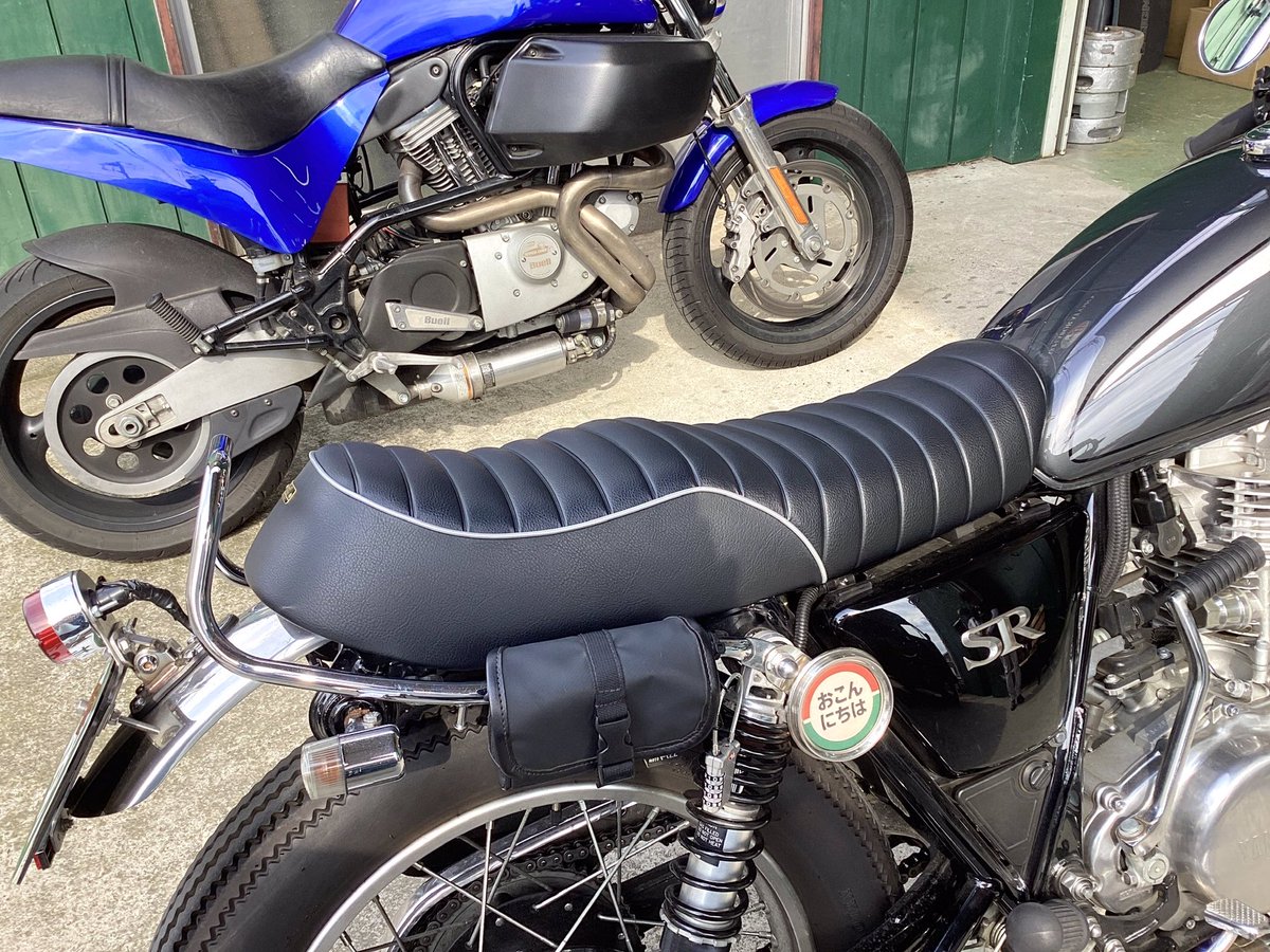 KandH_seat's tweet photo. 仕上がりましたシートのお引き取りご来店です！
既に弊社SR400用で一番シート高の高いテールホップシートをお使いいただいておりますが、タイヤを太くしたらだいぶ高くなってしまった模様、、😆
今回は低めの段付きシートをご選択いただきました！これで高い低いの二刀流ができますね！👍
新しいシートでもいっぱい走ってくださいね〜💨お買い上げ誠にありがとうございます！(staff o)