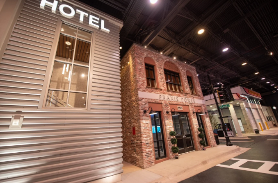 The exterior of a hotel located on a street corner in the technical training environment.
