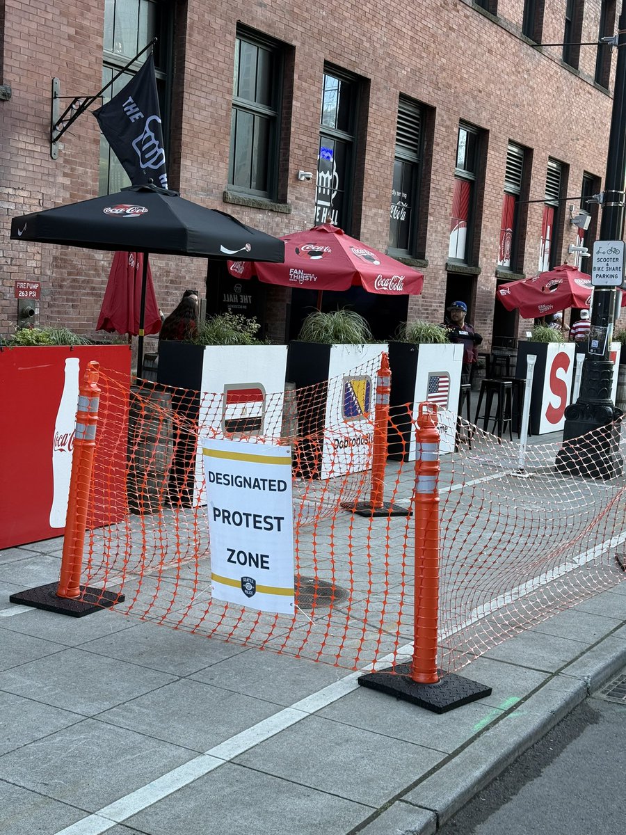 pnwprincess23's tweet photo. designated protest areas all over the seattle stadium vicinity, but all i’ve seen so far is a fan giving a red card to a doomsday preacher? https://t.co/FzncMdhLHN