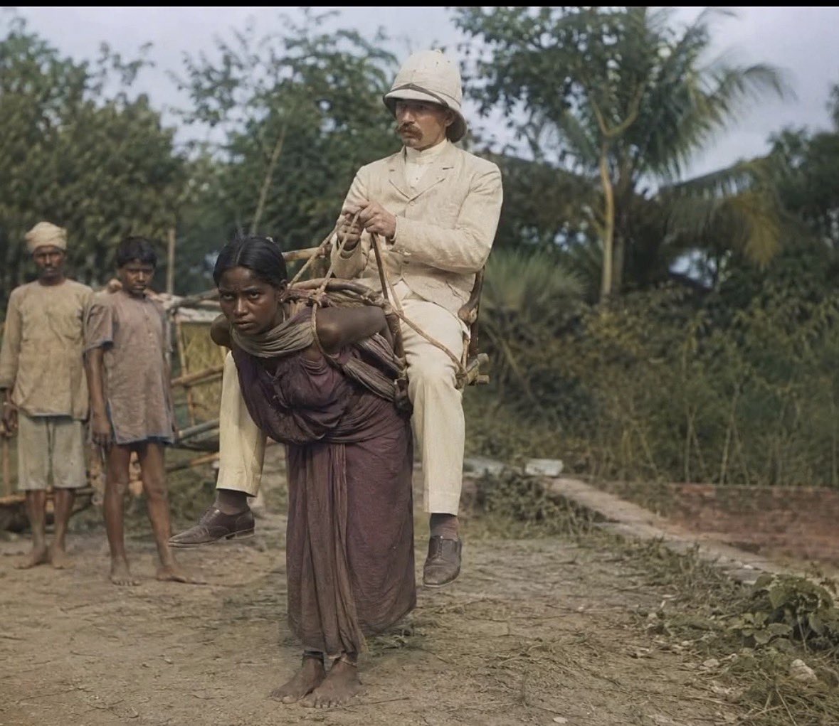 CommanMan777589's tweet photo. A Bengali woman carrying a British merchant on her back… 

📸 This photo was taken in 1903, at the height of British colonialism in the Indian subcontinent. This isn't just a picture… 

it's a slap in the face to all those who sing the praises of "Western civilization." This is the true face of colonialism, which they still try to beautify in history books. 

It's slavery and the humiliation of human beings, the crushing of human dignity, simply because they don't belong to the white race! And then they ask you about terrorism… 

The history of Western colonialism is full of massacres, slavery, plunder, and starvation… But they reduce terrorism to oppressed peoples struggling for their dignity! 🩸 

The effects of what British colonialism did in India—the killing, starvation, plunder, and contempt for humanity—are still evident today. Millions

 were killed, wealth was stolen, and generations were displaced… all under the banner of a false "enlightenment"!