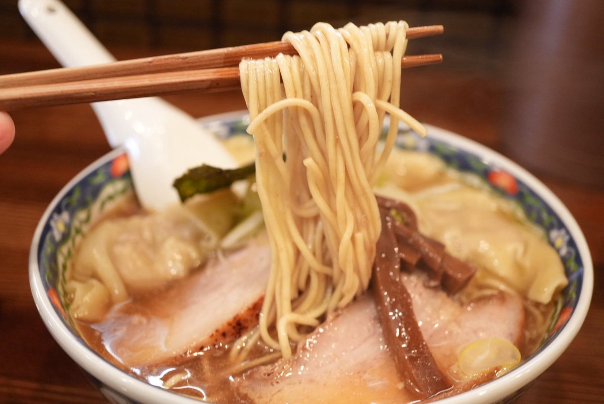 mitomi_emon's tweet photo. 東京・下丸子の住宅街に、ラーメン好きの巡礼地になりつつある一軒がある。間借り営業を経て、2024年に実店舗としてオープンした『奈つやの中華そば』。店名の「奈つや」は、奥様・奈津子さんの「奈つ」と、店主の修行先『びぎ屋』の「や」を組み合わせたもの。修行先への敬意と、家族の名前。その両方を大切にする姿勢が、この屋号に表れている。実際に店に立つ二人の接客もとても気持ちよく、人柄の良さがそのまま店の空気を作っているようだ。ちなみに、人気店ゆえ、現在は予約制を採用。朝7:28に予約サイトがオープンする仕組みだ。ちなみにこの時間は「なつや」に掛けたもの。そんな遊び心にも、この店の人柄が表れている。

いただいたのは「もちもち雲呑中華そば」。丼に顔を近づけると魚介の香りがふわりと立ち上がる。ファーストアタックで感じるのは煮干しの鮮烈な旨味。厳選された煮干しを贅沢に使いながら、エグみや苦味は見事に抑え込まれている。そこに鰹節や鯖節などの節系が重なり、香りに奥行きを生む構造だ。さらにその下から支えるのが鶏ガラと豚ガラの動物系出汁。魚介の輪郭を際立たせながら、味わいにはしっかりとしたコクが宿る。醤油ダレは芳醇でキレがありながら角が立たず、出汁の甘みをきれいに引き立てる。表面の香味油が熱を閉じ込め、最後まで煮干しの香りを鼻へと運んでくれる。

麺は菅野製麺所による全粒粉入りのストレート細麺。啜った瞬間に「パツン」と心地よく歯切れる食感で、スープの旨味をしっかりと持ち上げるど真ん中の設計。そしてこの店の代名詞ともいえるのが雲呑。岩手県産の希少なもち性小麦「もち姫」を100％使った皮は、一般的なつるりとした雲呑とは別物。まるで餅のような弾力を持つ“むっちり”とした食感が特徴だ。中には生姜の効いた肉餡。噛むたびに肉の旨味が広がり、生姜の清涼感がスープの旨味をきれいに引き締める。

気になった「茶碗カレー」も注文。ご実家の洋食店から受け継いだレシピで作る欧風カレーで、コクのある味わいが特徴。

鮮烈な魚介の香り、深いコク、そして餅のような雲呑。しっかりとしたインパクトがありながら、どこか優しさも感じさせる一杯だ。修行先で培った醤油ラーメンの技術を土台にしながら、「もち姫」の雲呑という個性を重ねた構成。その完成度は、わざわざ下丸子まで足を運ぶ理由として十分すぎる。少しハードルはあるが、それでも食べたいと思わせるラーメン。ご馳走様でした。
•