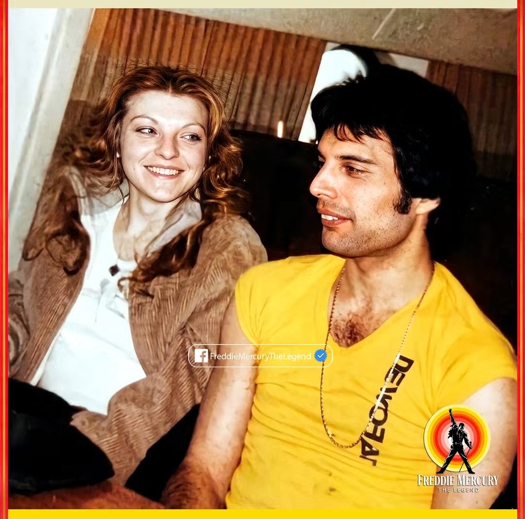 CrazyVibes_1's tweet photo. She was 19 years old when she first met him in a London boutique. Today she is 74, and after more than 57 years, she still keeps one of the most personal promises she ever made to him. She has never told anyone where she finally laid his ashes to rest.

This was long before the legend of Freddie Mercury existed. Long before the voice that would fill stadiums around the world. At the time, he was simply Farrokh Bulsara, a shy young graduate from art college who spent his time browsing the racks at Biba, a fashionable boutique in Kensington.

Behind the counter worked Mary Austin, a quiet young woman from Fulham. Her parents were deaf, and she had left school at fifteen to help support her family. By nineteen, she had found work at one of London’s trendiest shops.

He was 24, she was 19, and for six months he came into the shop without ever finding the courage to speak to her. He would pretend to browse the clothes while stealing quick glances in her direction. It seems almost impossible now: the man who would one day command crowds of 100,000 people couldn’t bring himself to ask one woman out to dinner.

Finally, on September 5, 1969—his birthday—he gathered the courage and invited her out.

Mary thought it was just a casual outing with friends. She had no idea he meant it as a date.

But that evening something changed. The nervous young man who had been quietly visiting the shop opened up. They talked for hours, and within five months they were living together in a small flat near Kensington Market.

At that time, Queen did not yet exist as a global phenomenon. Freddie was chasing a dream with a band that very few people believed in. Mary worked and paid the rent, bought the groceries, and supported them both while he focused on music. When others doubted him, she believed in him completely.

When Queen was released in 1973, Mary was by his side. That Christmas, only months after the album came out, Freddie proposed.

True to his dramatic personality, he presented her with a small box. Inside was another box. And inside that one, yet another. At the very center was a jade ring.

He asked her gently,
“Which hand should I put this on?”

She replied, “The ring finger on the left hand.”

Then he smiled and said,
“Because… will you marry me?”

Mary said yes.

But as Queen’s fame grew, Freddie’s life became more complicated. During the mid-1970s he began having secret relationships with men. In 1976, three years after their engagement, he finally spoke honestly with Mary.

“He told me he thought he might be bisexual,” she later said.

Mary looked at him and quietly answered,
“No, Freddie. I don’t think you’re bisexual. I think you’re gay.”

Their engagement ended, and so did their romantic relationship. Yet the deep bond between them never disappeared.

Mary moved into a nearby flat that Freddie helped provide through his company. She continued working with Queen’s management and remained an important part of his life. Freddie often said she was still the most important person to him.

“All my lovers asked why they couldn’t replace Mary,” he once said. “But it’s impossible. To me, she was my common-law wife. To me, it was a marriage.”

He even wrote the song Love of My Life for her—one of Queen’s most beloved ballads.

Mary eventually built her own life. She had two sons, married, and later divorced. Yet throughout everything she remained close to Freddie—the one person who knew him before the costumes, before the fame, before the world knew his name.

In 1987, Freddie was diagnosed with AIDS after testing positive for HIV. At that time there was no effective treatment, and the illness was widely seen as a death sentence.

He kept his condition private from the public. But Mary knew.

She visited him often during his final weeks. On November 24, 1991, at his home, Garden Lodge, Freddie Mercury passed away at the age of 45.

Mary was holding his hand.

Before he died, he asked something very personal of her. He had seen how the graves of famous people could become places of disturbance or obsession. He wanted peace. He wanted privacy.

So he asked Mary to scatter his ashes somewhere secret—and never tell anyone where. Not his parents. Not his bandmates. No one.

For two years, she kept the ashes in her bedroom because she could not yet say goodbye. Then one quiet morning, when she was certain no one was watching, she took them away and fulfilled his wish.

She scattered his ashes at the place he had chosen.
And she has kept that secret for more than three decades.

Many theories have circulated: Lake Geneva, the island of Zanzibar where he was born, a tree in his garden, or Kensal Green Cemetery. Mary has either denied these ideas or simply refused to comment.

In Freddie’s will, he left Mary 50% of his estate, including Garden Lodge. After his parents later passed away, their share also went to her. Today she receives 75% of the future earnings from his estate. The film Bohemian Rhapsody alone reportedly brought her about $75 million.

Some people thought that was excessive. But Freddie’s own mother understood.

Freddie once told Mary,
“If things had been different, you would have been my wife, and it would all have been yours anyway.”

In 2023, Mary auctioned nearly 1,500 of Freddie’s personal belongings, including the piano on which Bohemian Rhapsody was written. Nearly 140,000 people visited the exhibition before the items were sold. Mary explained that it was time to let go of some things and close a chapter of her life.

Today she still lives quietly behind the walls of Garden Lodge, the home where Freddie spent his final years. Outside the gate, fans from around the world continue to leave flowers, messages, and tributes.

Mary Austin remains the guardian of his memory—and the keeper of his greatest secret.

“When he died,” she once said, “I felt as though we had been married. We lived through everything together—better or worse, richer or poorer, in sickness and in health.”

Their story challenges the way people usually think about love. It began as romance, changed into something deeper, and endured long after the relationship itself ended. It lasted until Freddie’s final breath—and in many ways, it still continues.

She was 19 when they met in that London boutique.

She is 75 now.

And she still has never told anyone where she took him. 

📷Restoration, Remastering & Colorization by Freddie Mercury - The Legend 😎