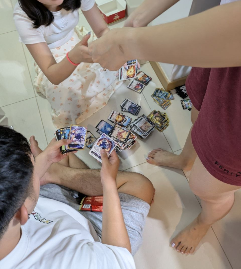 Joshuayapable's tweet photo. Family was over to chill out after dinner. It all randomly started with Damien asking what "Azuki" is after seeing all the collectibles in my room.

One conversation and less than an hour in, everyone was taking turns to gasp in shock pulling multiple SRs & AAs.

My heart is so filled tonight 😭🩷
S/O to lil sis Elinoar for sorting the cards like an G and wifey pulling a top hit Charizard to end the night off.

The chase for portrait continues..