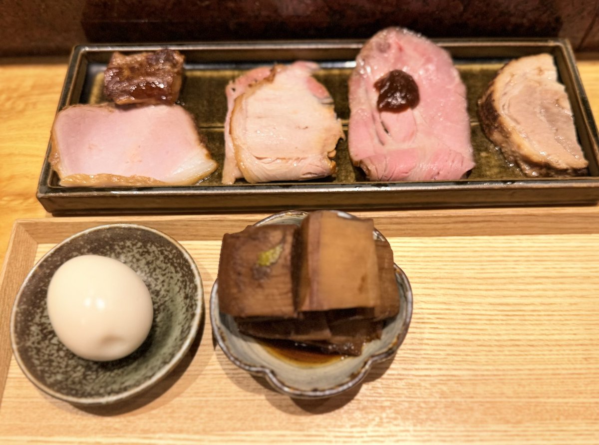 interrecoba's tweet photo. 松戸　中華蕎麦とみ田
つけめん TOKYO-X純豚骨つけダレ（小） +  特選全部トッピング〈味玉ver〉  + 生ニンニク +辣油辛味 + 十四代 万虹 + 稲里 純米大吟醸 日々是好日

土曜日は麺活仲間のお力添えで訪麺出来て感謝の1日☆
豚骨ダレでどうしても食べたかったので本当にありがたい。
さて、この日は十四代の万虹からスタート。最後の半合だったのでラッキーでした。氷温熟成させた特地区の山田錦の35%のアル添のこちらはリンゴのような甘みを感じます、てゆーか甘ーい！そして旨い。
豚骨魚介の方より後に純豚骨の提供となるので特選やメンマは先出しで。丁寧に準備されるワカメもお酒を進めてくれる大きな存在。そして特選のお肉達も。
そしてつけめんはこの日も瑞々しい麺で塩だけで頂いてもパーフェクト。どうしても食べたかった豚骨はどうしてこれだけ豚骨で上品な仕上がりになるのかと感心してしまいます。
遅れてドロップの稲里は米の旨味と大吟醸らしい香りで安定の旨さ。
辣油を麺に浸しても豚骨ダレは旨い。
生ニンニクを豚骨ダレに全投入してもジャンク感よりは味の深みが増す感じが良いですね。
麺を食べ切ってからの出汁割りですが、最近は常にビシッと上品な魚介感がガンギマリで旨すぎます。
多幸感に包まれながら退店すると店外にはヘッズ達が。
イベントも最高ですが、通常回もやはり最高ですね。
