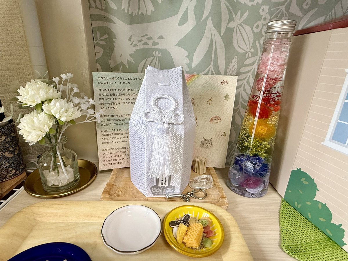 sparklemoon's tweet photo. ゴマヲ氏旅立ちから昨日で三十五日。
造花だけじゃ申し訳なく虹色のハーバリウムを入手しました🌈

プリザーブドフラワーと迷ったけど、こちらの方がまだ長持ちしてくれそうだったので。

綺麗（癒）

（写真は2025.6.30）
#ゴマヲ氏メモリアル #ハムスター      #想い出 #記録 #供花 #ハーバリウム https://t.co/YyHZfHqmGU