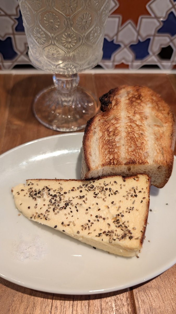 _tabesugi_kun's tweet photo. これはお通しに出てきたバスクチーズケーキ。胡椒と塩が添えてありオリーブオイルをぶっ掛けて食べろという。パンに乗せるとチーズの癖が消えてただ旨いだけの���リームになってしまい
これは令和のお通しグランプリ決定です。まじうめえ https://t.co/8YcSfPcGRu