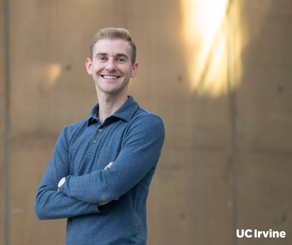 Matthew Landry, assistant professor of population health & disease prevention, stands with arms crossed in front of a blurred background. The words "UC Irvine" appear in the bottom right corner.