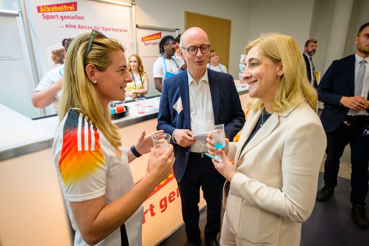 Am Stand des Aktionsbündnisses „Alkoholfrei Sport genießen“ steht Nina Warken gemeinsam mit dem Leiter des BIÖG, Johannes Nießen und Fußball-Weltmeisterin Nia Künzer, die auch Botschafterin des Aktionsbündnisses ist.