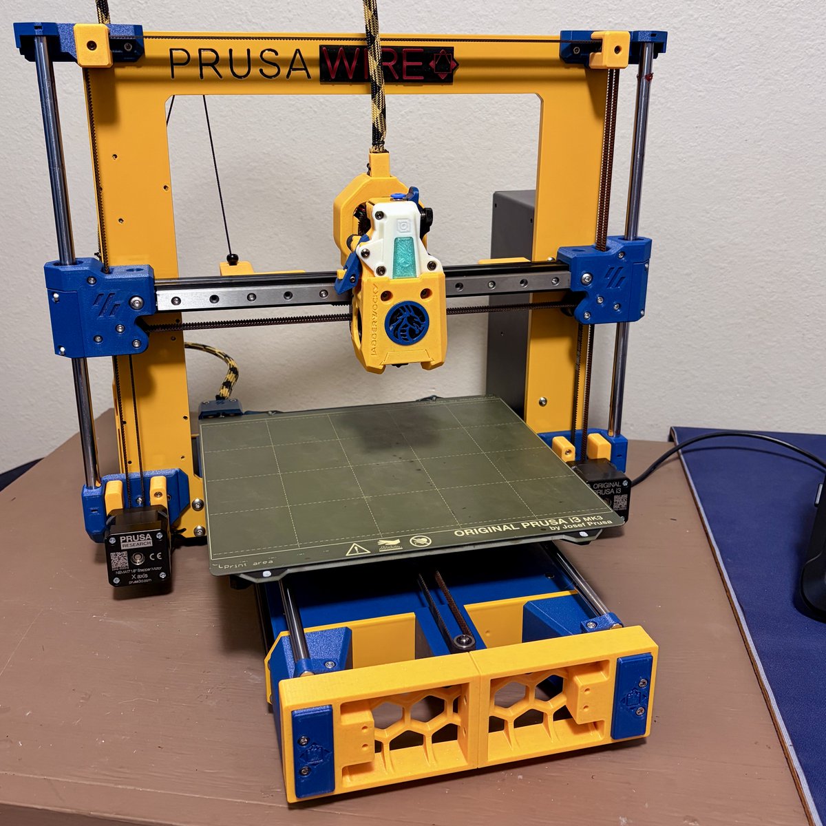 joescalon's tweet photo. How it started and where I am on my Prusawire build. Time to work on firmware. Colors @LDOmotors LarchGold ABS and @West3DPrinting Blue PC-CF. Just waiting on a @BIQU_Makers Orange cool plate.
Also, yes that is a Jabberwocky toolhead.
@Positron3d #prusawire https://t.co/3asg3oVdkI