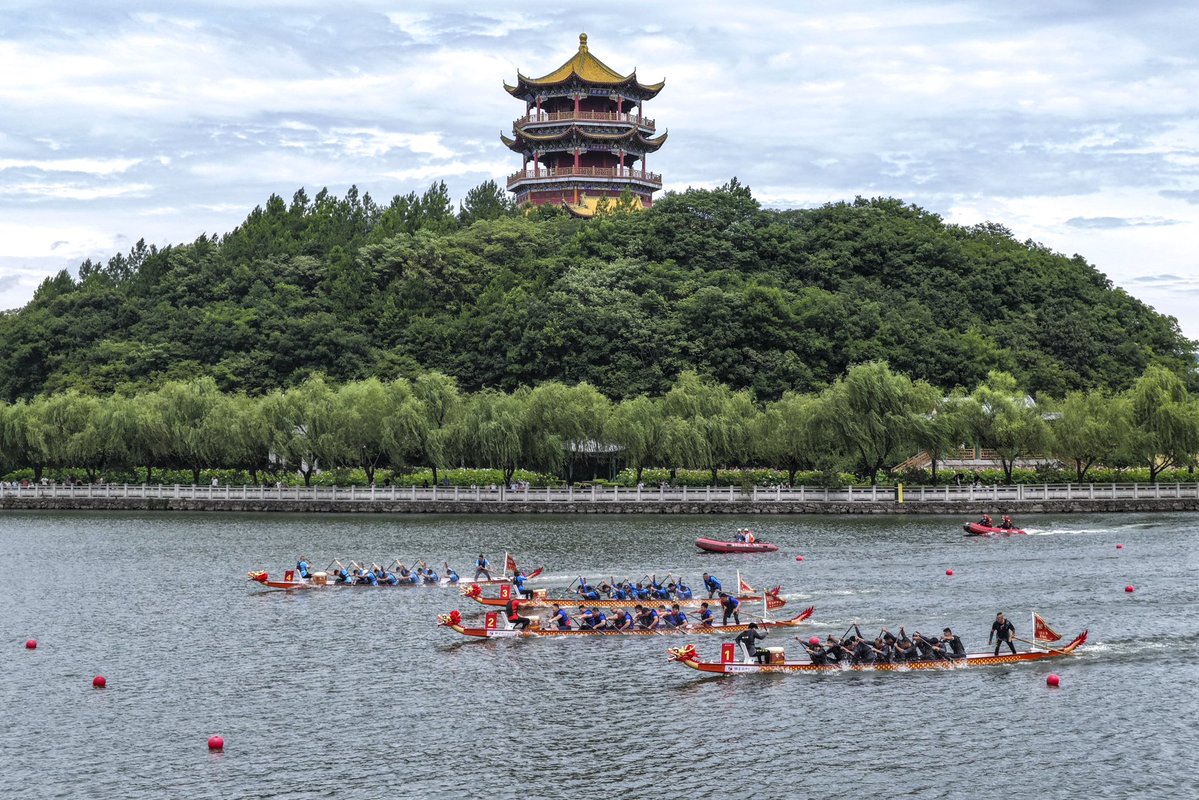 DongyangChina's tweet photo. On the Loong Boat Festival, Hengdian Town, Dongyang City, the grand opening ceremony of the 2026 Yuanming New Garden Loong Boat Cultural Festival took place on the Fuhai Lake. The lake surface was sparkling, and the sound of drums and music echoed from the shore, immersing the atmosphere in the traditional Chinese festival. The event gathered professional loong boat players from across the country, film crews, corporate employees, internet celebrities, and families with children, promoting the Loong Boat Festival customs through loong boat racing.